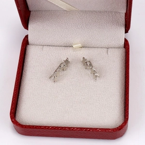 Detailed view of silver star crawler earrings inside a red jewelry presentation box