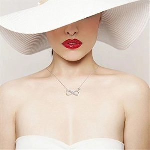 Close-up of elegant S925 sterling silver infinity pendant necklace worn by a fashion model