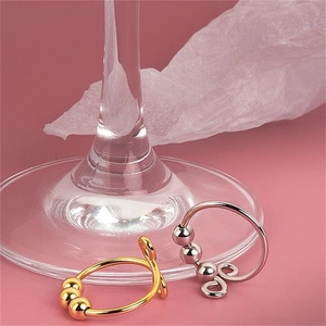 Detail of silver and gold spinning rings with movable beads for anxiety relief on pink backdrop
