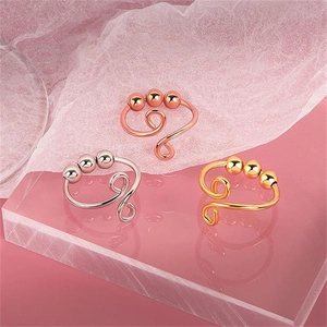 Detailed close-up of three-color spinning anxiety rings in gold, silver, and rose gold