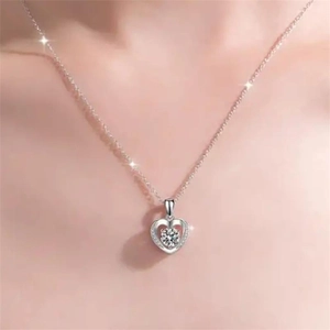 Gros plan d'un pendentif cœur en argent S925 avec zircone cubique porté par un mannequin