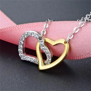 Detail of interlocking S925 silver and gold heart pendant with shimmering crystals
