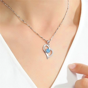 Close-up of S925 silver heart necklace with blue zircon pendant on a model neck