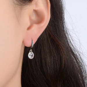 Close-up of S925 sterling silver hook earrings with faceted clear crystal on model