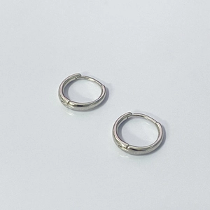 Dettaglio di orecchini a cerchio minimalisti in argento sterling S925 lucido a specchio