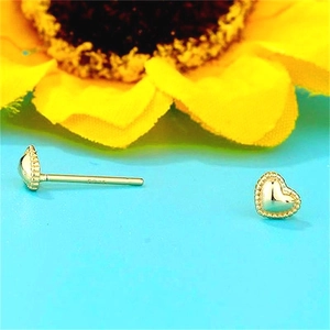 Détail de boucles d'oreilles cœur en argent S925 plaqué or avec poinçon de qualité