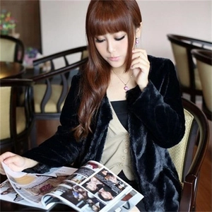 Chic women's black faux fur coat in mid-length cut, styled in a cozy cafe setting