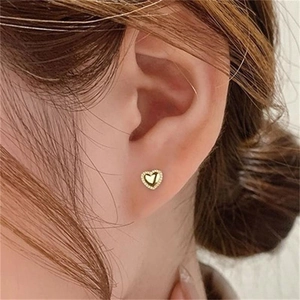 Boucles d'oreilles cœur en argent S925 doré avec cristaux portées par un mannequin
