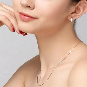 Minimalistische S925 Sterlingsilber Schlangenkette und kleine Creolen am Modell getragen