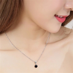 Détail d'un collier en argent S925 avec pendentif en agate noire sur un mannequin