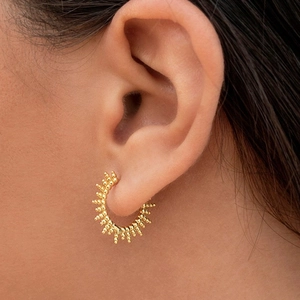 Elegante orecchino a cerchio raggio di sole in argento S925 placcato oro su modella