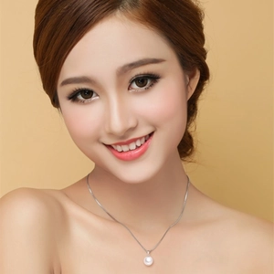 Elegant 925 sterling silver necklace featuring a round white shell pearl on a female model