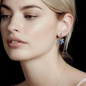 Sparkling S925 sterling silver snowflake earrings with blue marquise stones on model