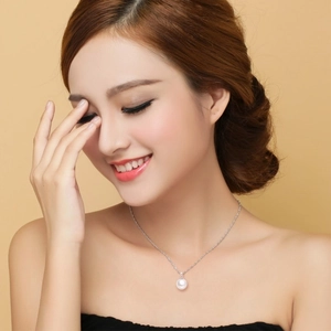 Elegant 925 sterling silver necklace featuring a round white pearl pendant on a model