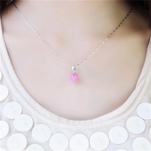 Détail d'un collier pendentif sphérique rose porté par un mannequin pour le style