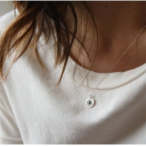 Detail of S925 sterling silver round pendant with black floral enamel on model neck