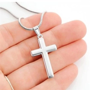 S925 sterling silver cross pendant necklace held in palm with polished mirror finish