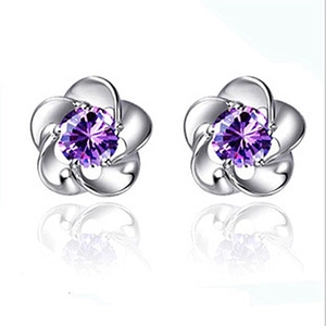 Dettaglio di orecchini a lobo a fiore in argento con zircone viola e riflesso lucido