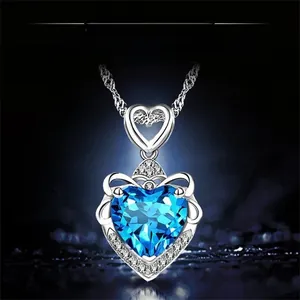 Détail d'un pendentif cœur en topaze bleue avec sertissage couronne en argent et chaîne fin