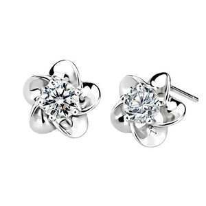 Dettaglio macro di orecchini a fiore di prugno in argento 925 con zirconi cubici