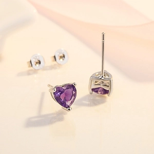 Dettaglio macro degli orecchini a cuore in argento S925 con gemma viola e punzone