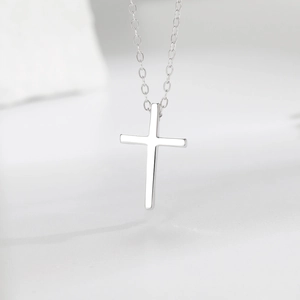 Close-up of polished S925 sterling silver cross pendant with minimalist link chain