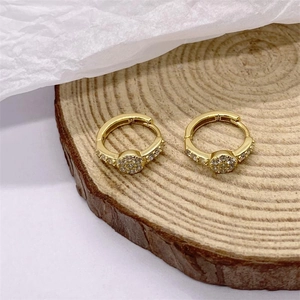 Sparkling S925 sterling silver hoop earrings with pavé cubic zirconia on wood background