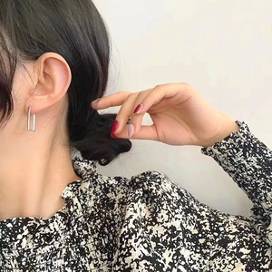 Close-up of minimalist S925 sterling silver rectangular hoop earrings worn by a model