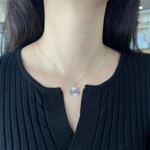 Close-up of S925 sterling silver sunflower necklace on model's neck with black background