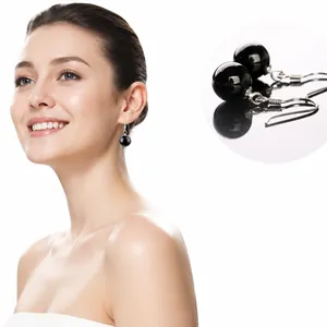 Dettaglio di orecchini a gancio in argento S925 con perle di agata nera su un modello chic