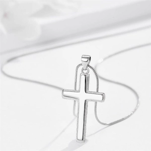 Gros plan détaillé du poinçon S925 sur le pendentif croix en argent et la chaîne fine