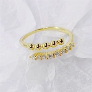 Macro detail of 18K gold S925 silver ring featuring gold beads and pavé set zircons