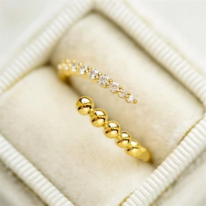 Detail of S925 silver gold-plated ring with zircon row and beads on velvet box