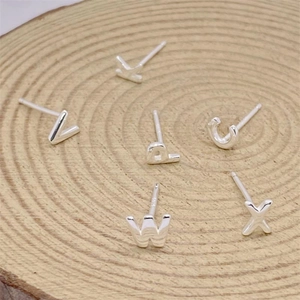 Polished S925 sterling silver alphabet stud earrings set on a rustic wooden base