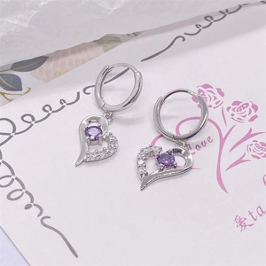 Detail of S925 silver hollow heart earrings with purple stone and white cubic zirconia