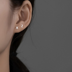 Detailed view of S925 sterling silver minimalist X and Z alphabet stud earrings worn on ear