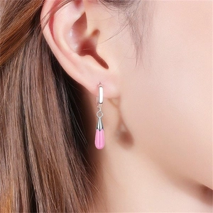 Close-up of pink opal teardrop earrings worn on ear showing elegant silver hooks