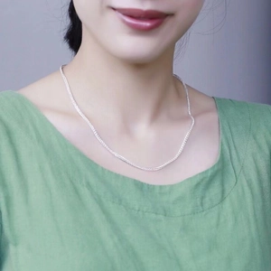 Close-up of S925 sterling silver Chopin chain necklace on female model with green top