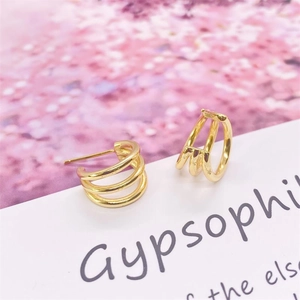Gros plan de boucles d'oreilles minimalistes dorées en argent S925 à triple créoles