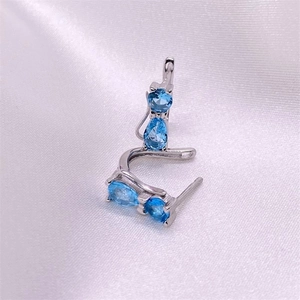 S925 sterling silver cat earrings with blue zircon stones on a white satin background