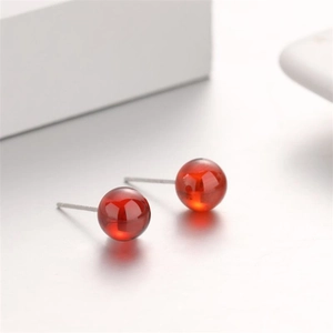 S925 sterling silver stud earrings featuring round red garnet stones on white props