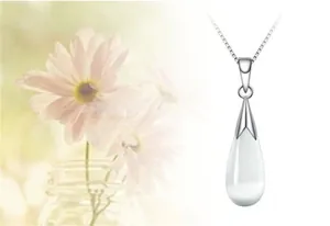 Detail of white cat's eye stone teardrop pendant on minimalist silver chain necklace
