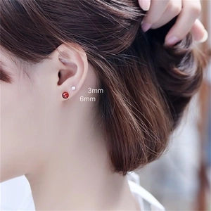 S925 sterling silver garnet stud earrings shown in 3mm and 6mm sizes on a model