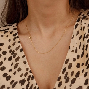 Detail view of gold S925 sterling silver S-letter pendant on a minimalist chain