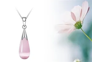 Close-up of teardrop-shaped pink cat's eye stone pendant on a silver-tone chain