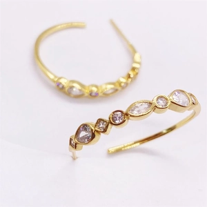 Macro shot of gold C-shaped sterling silver stud earrings with sparkling cubic zirconia