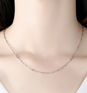 Close-up of S925 sterling silver chain featuring delicate cut-out floral spacers on neck