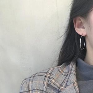 Close-up of polished silver hoop earrings on a model for a minimalist fashion look