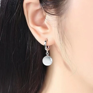 Vintage S925 sterling silver hoop earrings with white cat-eye stone pendant on model