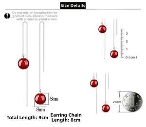 Macro detail of 8mm red agate bead drop earrings with 9cm long silver tassel chains